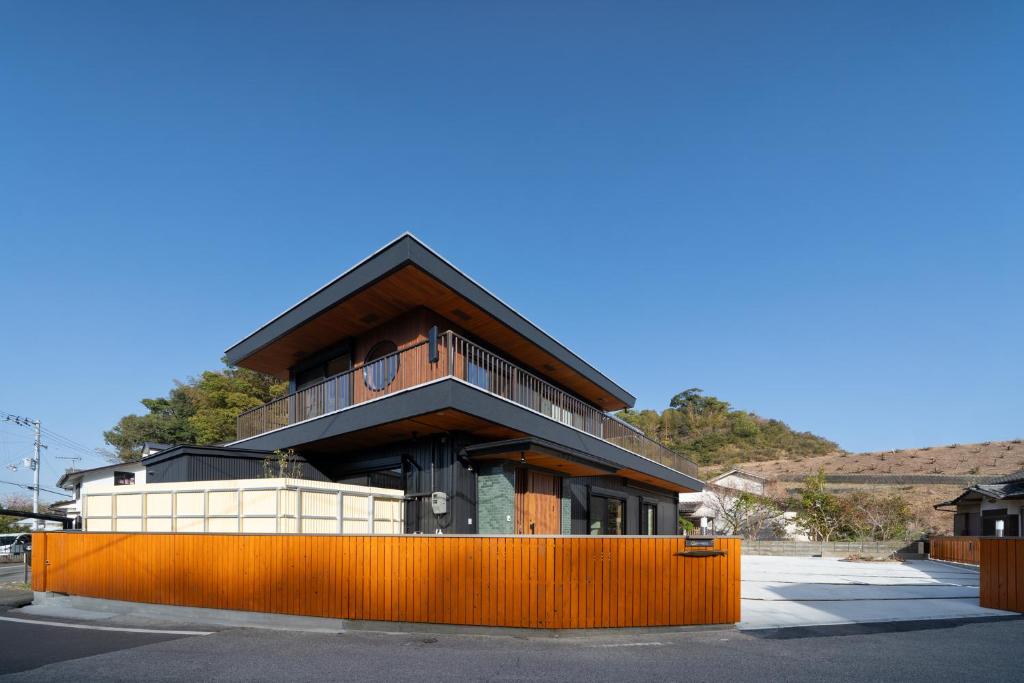 a building with an orange fence in front of it at URADO TERRACE Private villa 無料駐車場4台 最大10名 桂浜近く ジャグジー シアタールーム完備 in Kochi