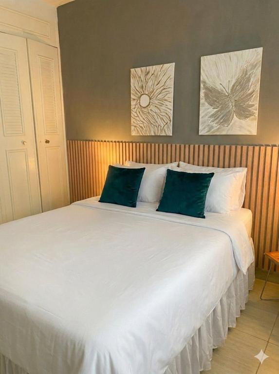 a large white bed with two green pillows on it at Tu Espacio en Ibague in Ibagué