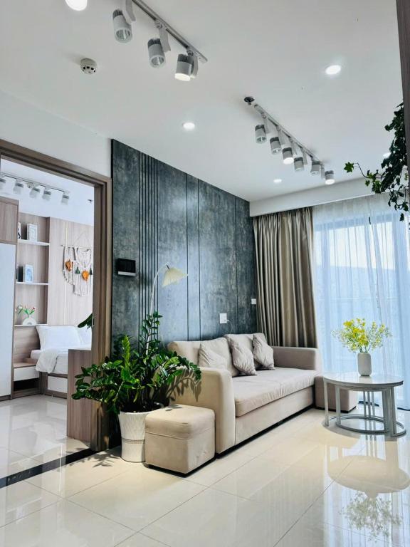a living room with a couch and a bedroom at AC Nera Garden Apartment in Thôn Văn Dương