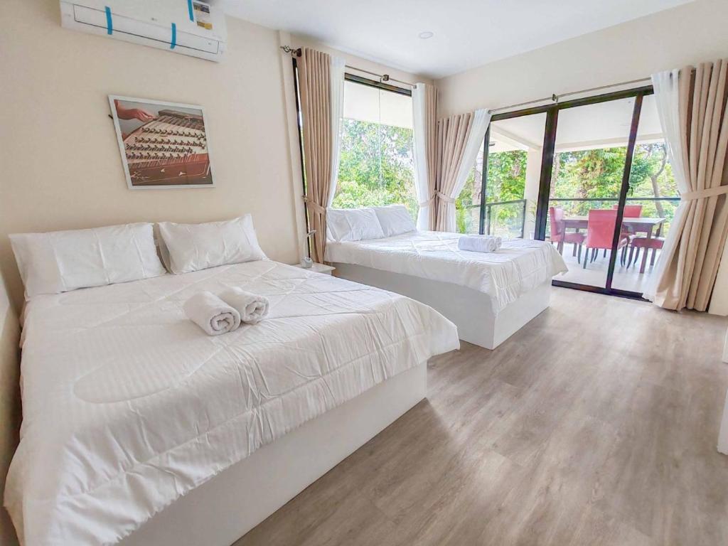 a bedroom with two beds and a balcony at Caliraya Music Camp in Cavinti