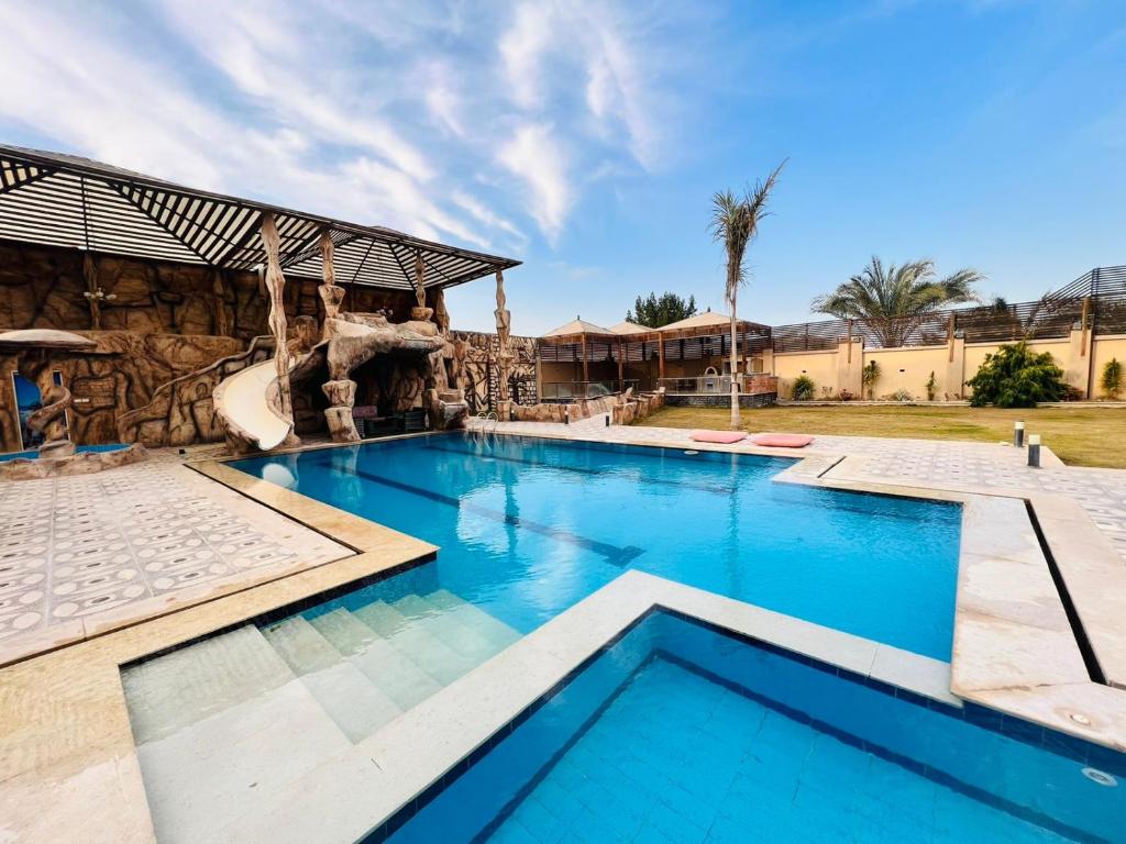 a swimming pool in a resort with a slide at Dreams Garden VIP Villa in Sphinx International Airport