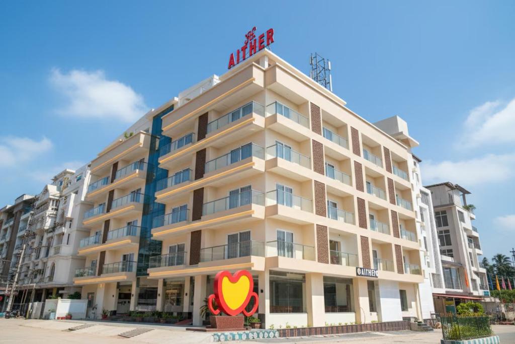 a building with a hotel sign on top of it at Aither in Digha