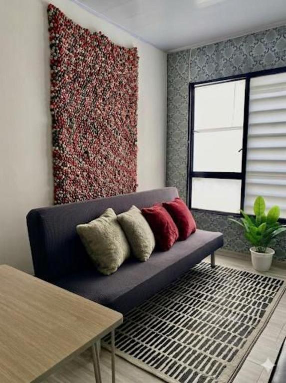 a living room with a blue couch with four pillows at BORA, Apto 301 Tu Espacio Fuera de Casa in Ibagué