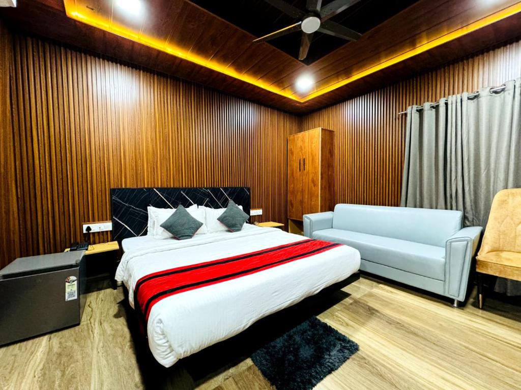 a bedroom with a bed and a couch and a chair at HOTEL N K RESIDENCY in Guwahati