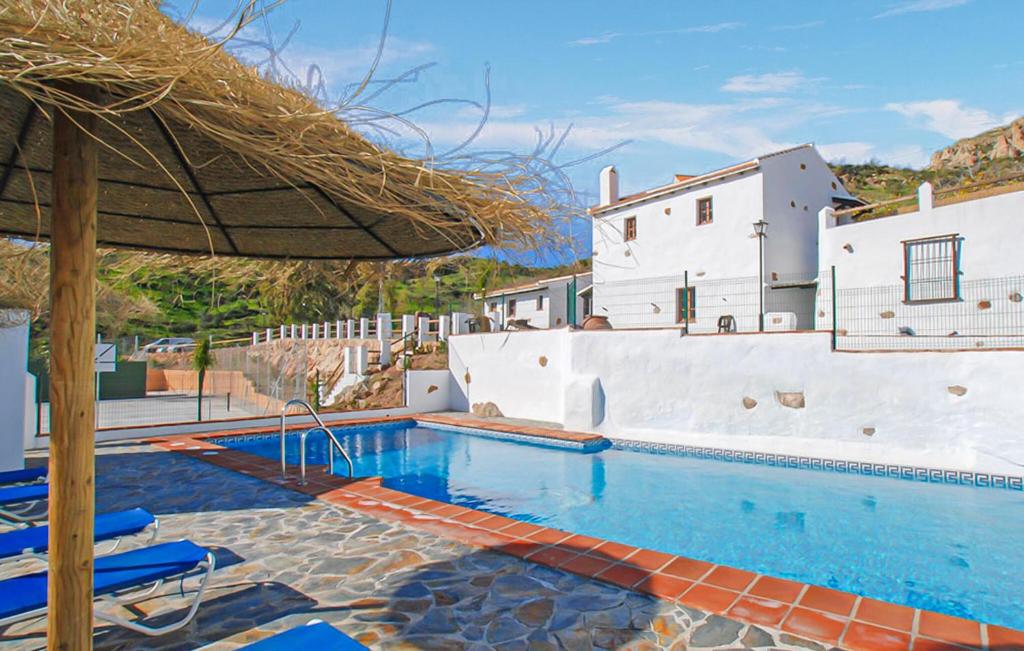 a pool with chairs and an umbrella and a building at La Casa Grande in Málaga