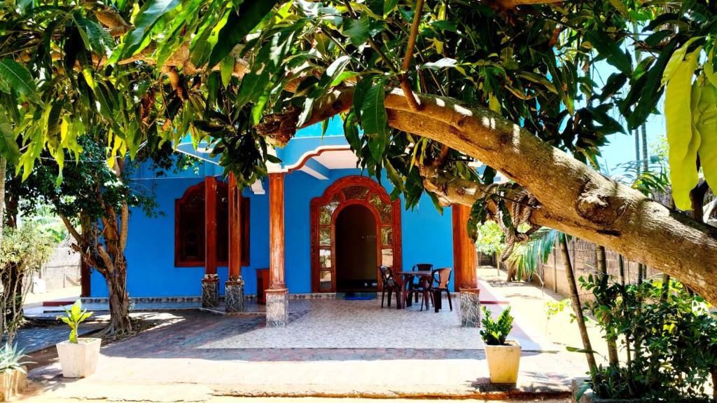 a blue house with trees in front of it at Nilaveli Better Beach Resort in Nilaveli