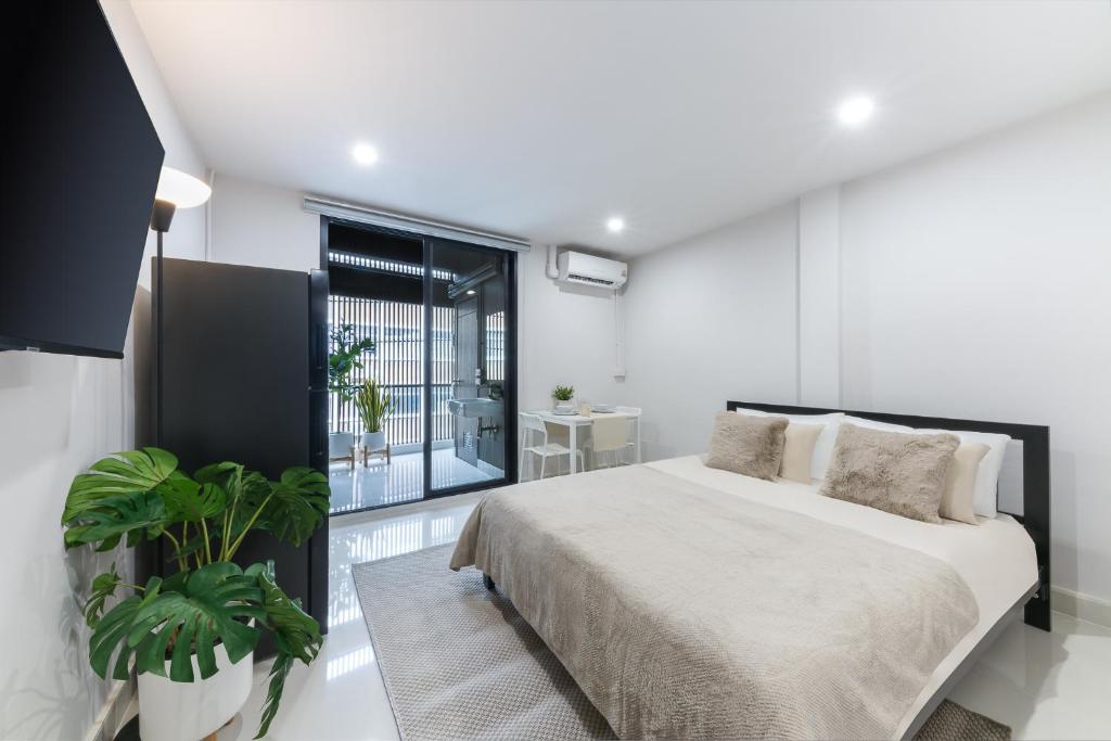 a bedroom with a bed and a large window at Petchaburi31 Platinum Suite Home in Bangkok