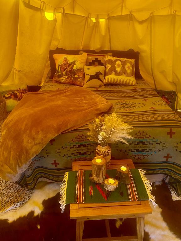 a bedroom with a bed and a table with a table at Kiowa Teepee at Nomad Landing in Clayton