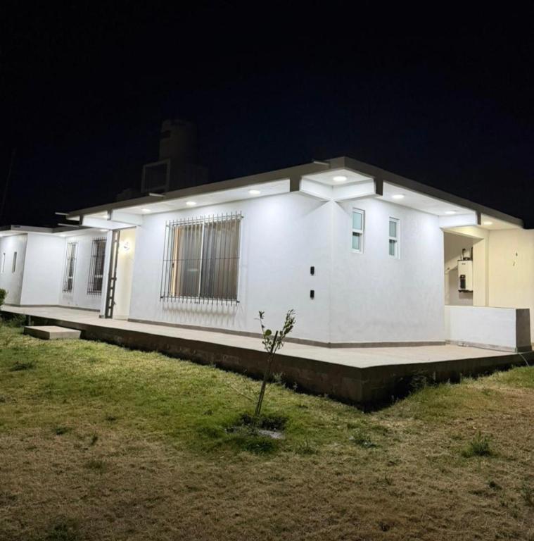 a white house at night with a plant in the yard at Casa Azteca de Oro in San Sebastian Xolalpa
