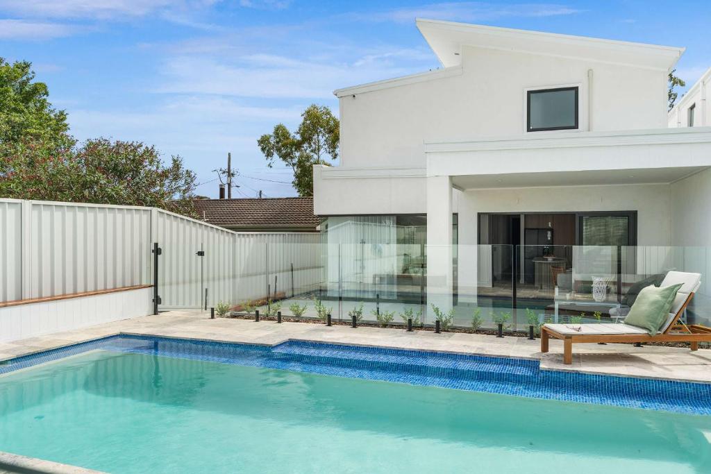 a swimming pool in front of a house at Beachside on Beecroft in Huskisson