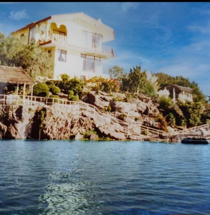 a house on a cliff next to the water at RosePlace Valsequillo in Durazno
