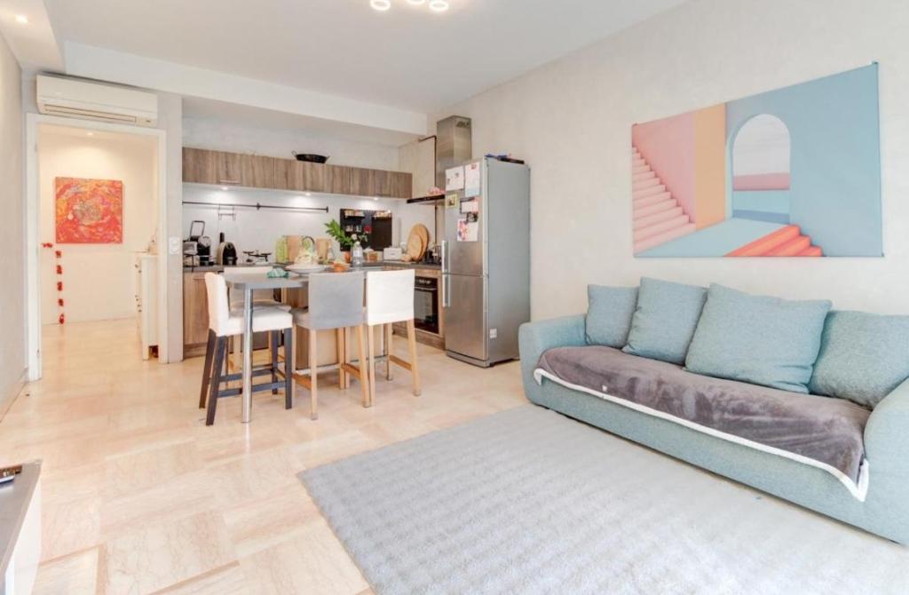 a living room with a couch and a kitchen at La Lanterne Plage in Nice