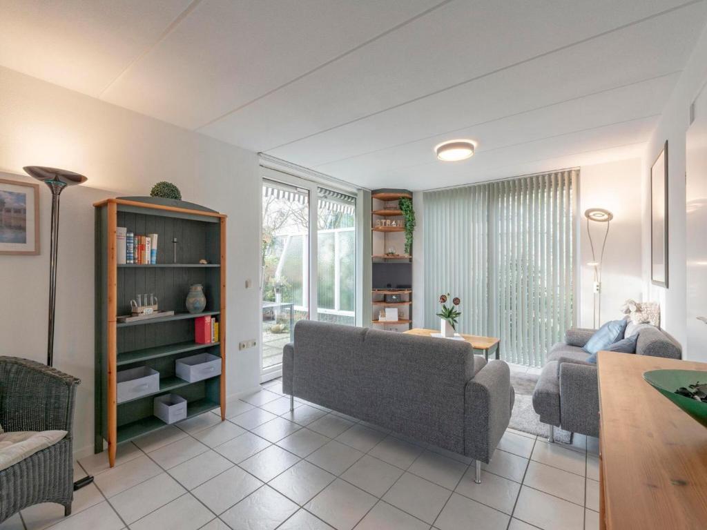 a living room with a couch and a table at Holiday Home near Dutch Beach with Pool in Sint Maartensvlotbrug