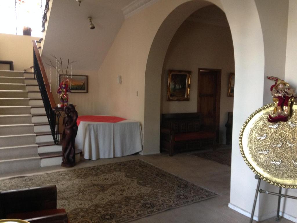 a hallway with a table and stairs in a house at Mansion Samzara Hosteleria in Sangolquí