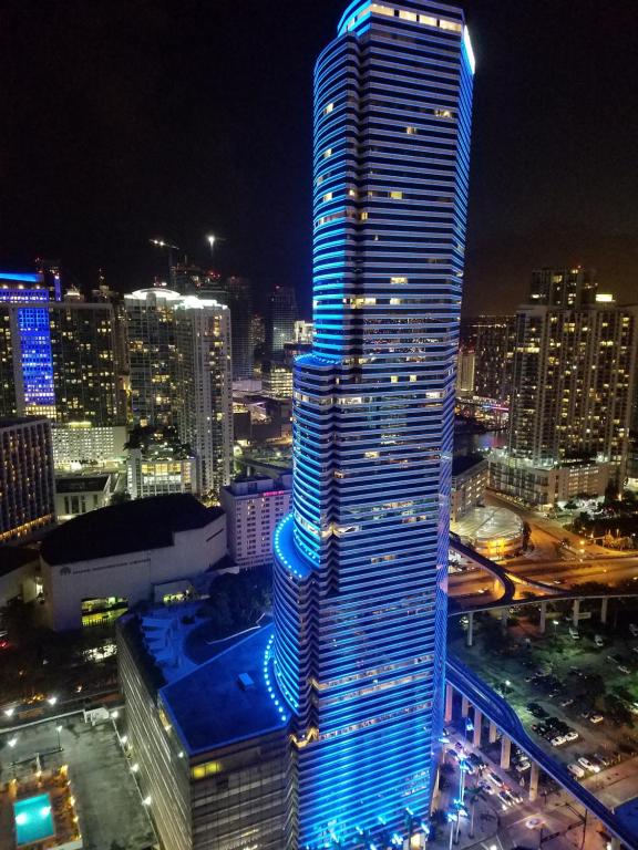 a tall building with blue lights on it in a city at Downtown Miami Deluxe Apartment in Miami