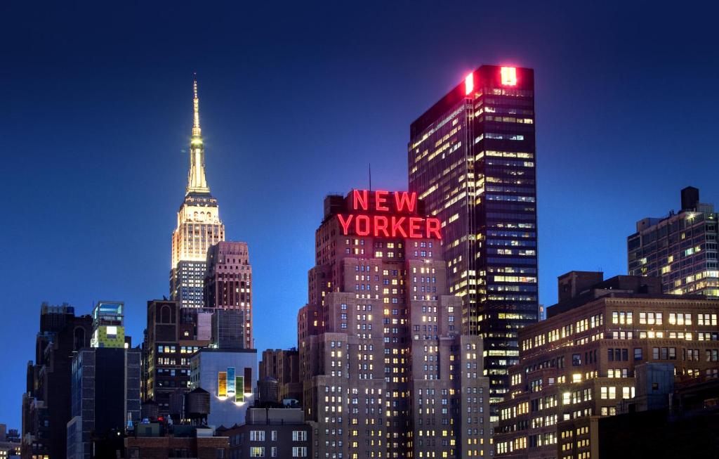 a city at night with tall buildings and a clock tower at The New Yorker, A Wyndham Hotel in New York