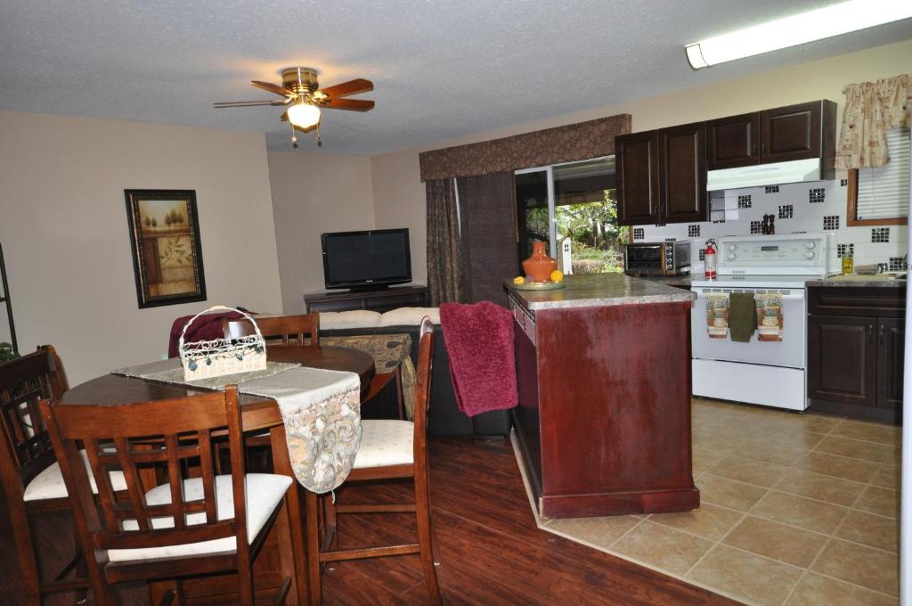 a kitchen and living room with a table and chairs at Garden House in Courtenay