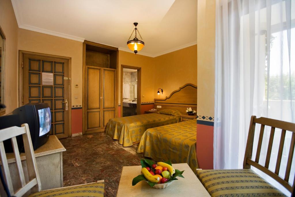 a hotel room with two beds and a television at Marvıda Hotel Akman Park in Kemer