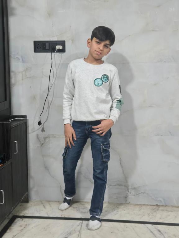 a young man standing in front of a wall at Taj Guest House in Agra
