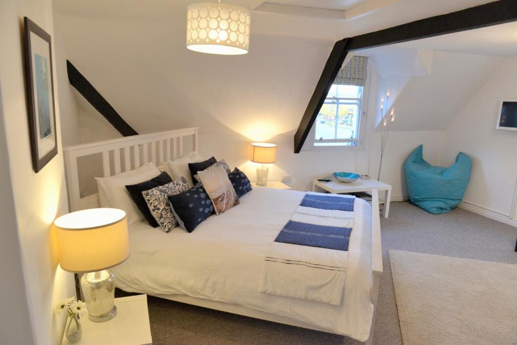 a bedroom with a large white bed with pillows at The Loft at Venga in Portishead