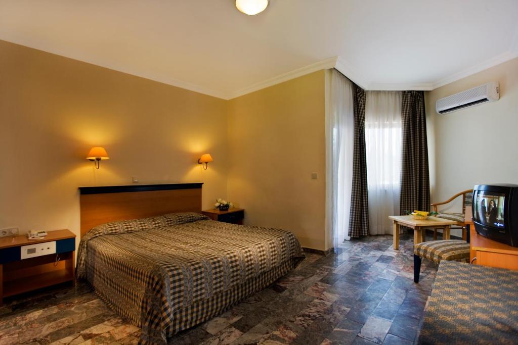 a hotel room with a bed and a television at Marvıda Hotel Akman Park in Kemer