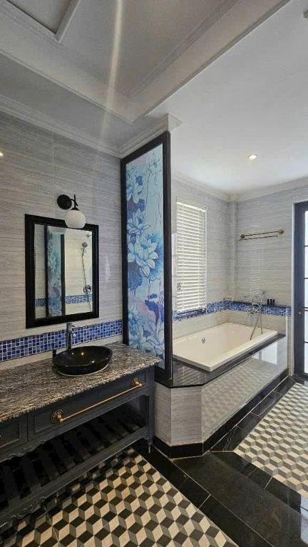 a large bathroom with a tub and a sink at Vườn vua thanh thuỷ in Ðồng Phú
