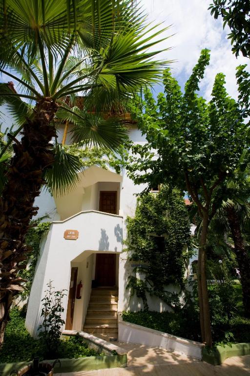 a white building with stairs and palm trees at Marvıda Hotel Akman Park in Kemer