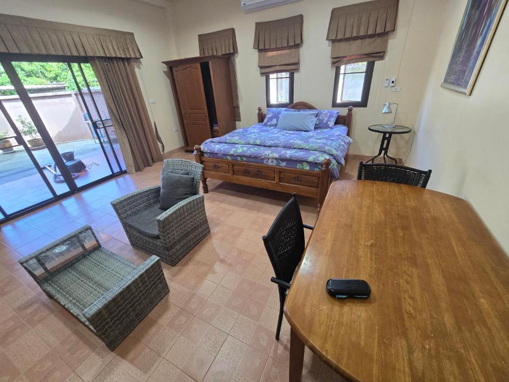 a living room with a bed and a table and chairs at Your space surrounded by Nature in Ban Mai Salae