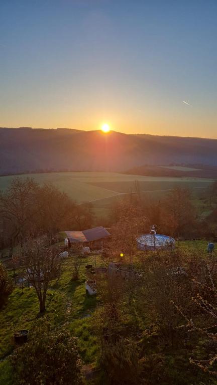 a sunset over a field with the sun in the distance at Ferienwohnung Pfalzblick in Bacharach