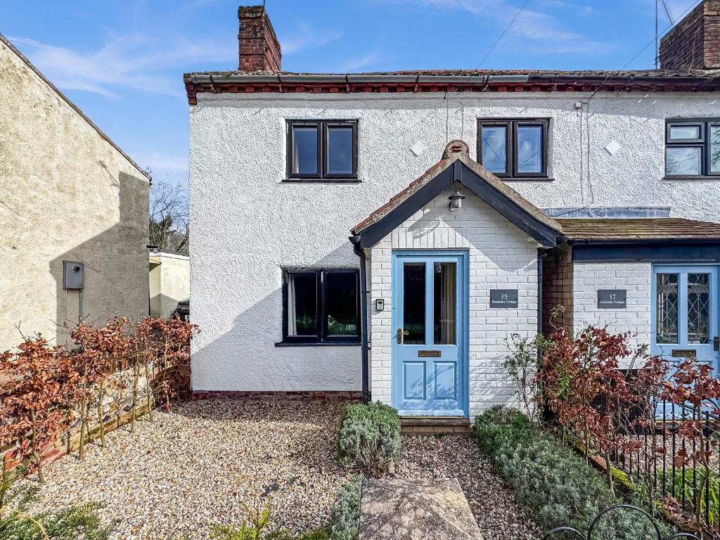 a white house with a blue door at Rosemary Cottage in Mattishall
