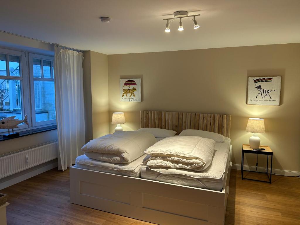 a bed in a bedroom with two lamps and a window at Seepferdchen in Timmendorfer Strand