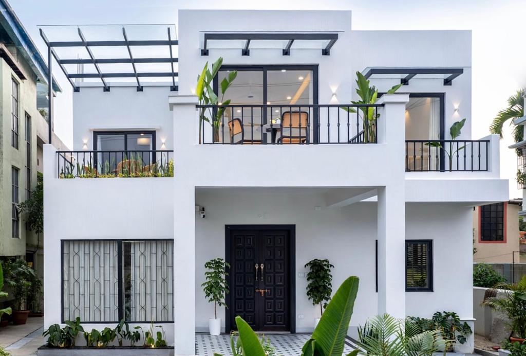 a white house with a black door at Villa Aura in Siliguri