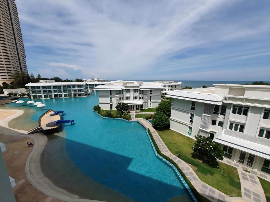 an aerial view of a large swimming pool with buildings at 1 Bedroom Beachside Condo in Cha-am in Ban Bang Sai Yoi (1)