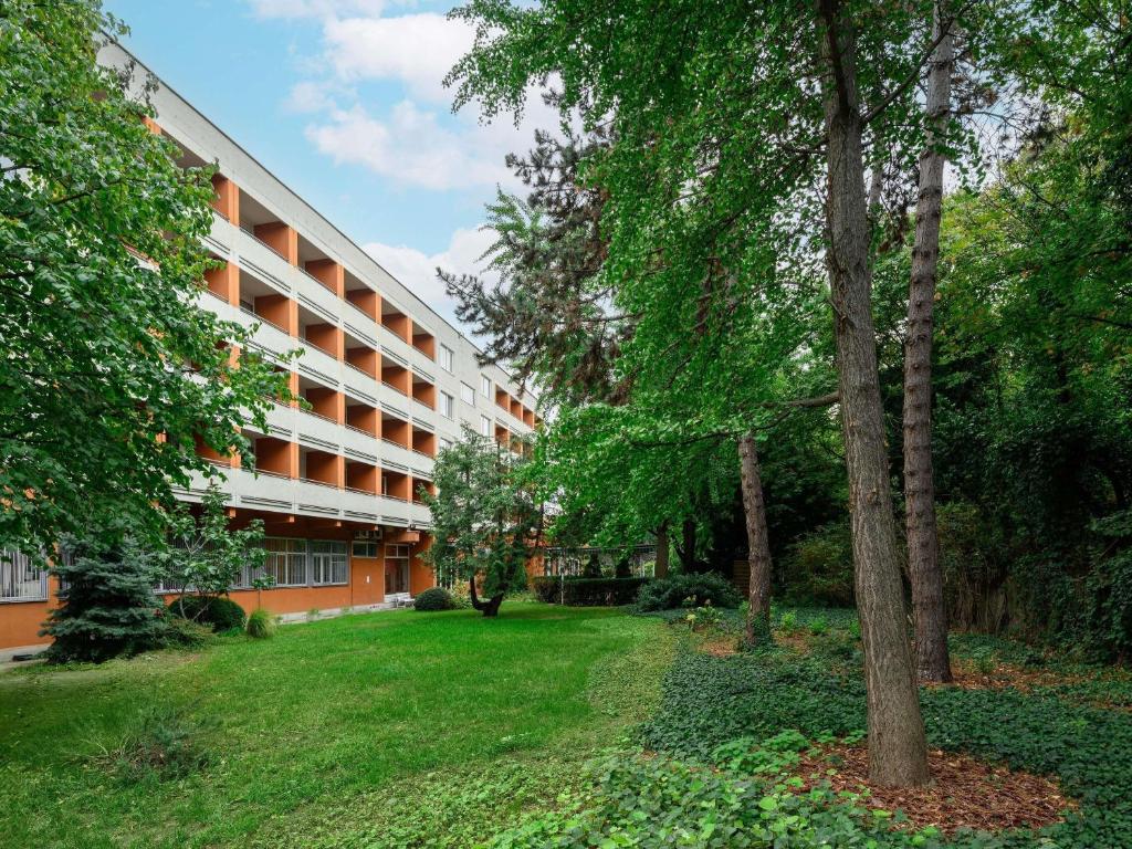 an apartment building with a lawn in front of it at Ibis Budapest Citysouth in Budapest