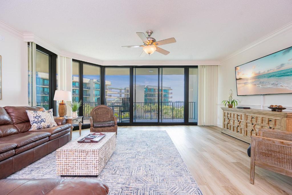 a living room with a couch and a ceiling fan at Phoenix on the Bay 1309 in Orange Beach