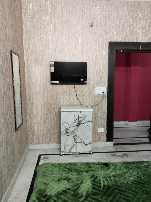 a room with a tv on a wall at Hotel Blue Heaven in Karnal