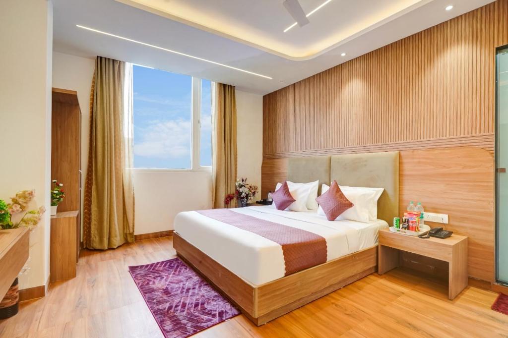 a hotel room with a bed and a window at Olive Aero Suites Plaza Inns Near Delhi International Airport in New Delhi