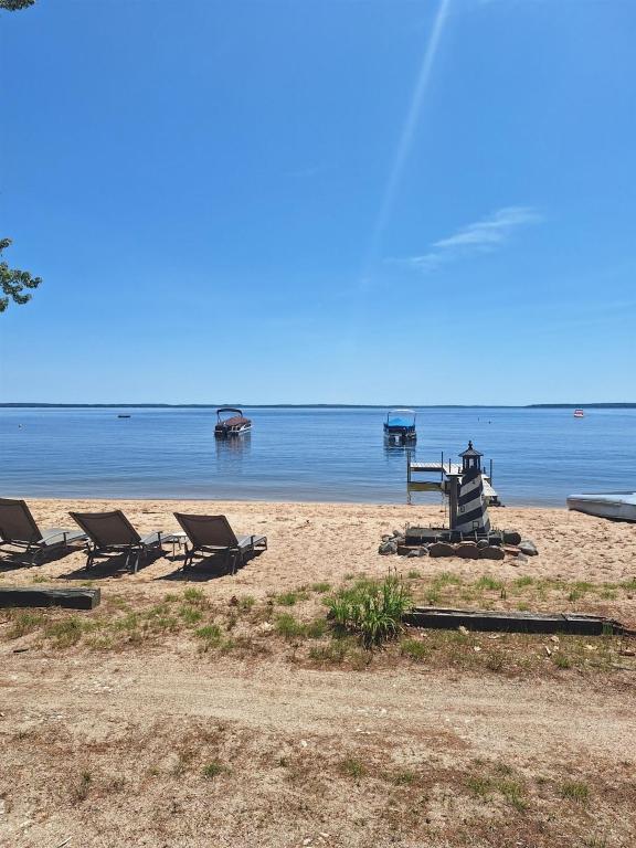 a group of chairs and a picnic table on a beach at 1901 HOUSE LIMIT 10 cottage in North Sebago