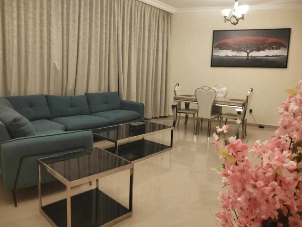 a living room with a blue couch and a table at imperial homes 2 in Ajman 