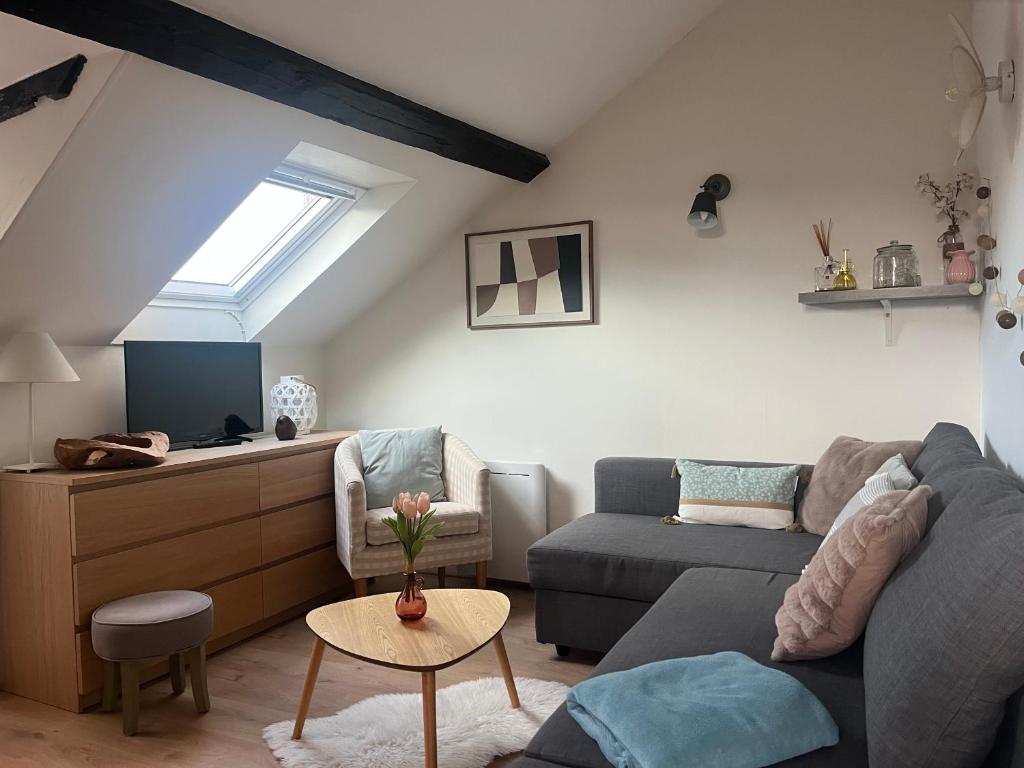 a living room with a couch and a table at Sur les Toits de Honfleur in Honfleur
