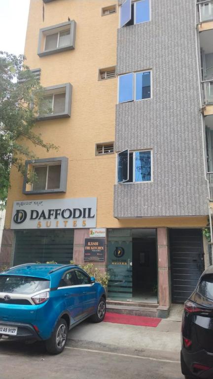 a blue car parked in front of a building at Daffodil Suites, Manyata Tech Park, Bengaluru in Bangalore