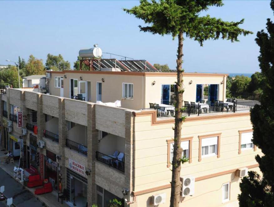 an apartment building with a balcony and a tree at Beachway Hotel in Side