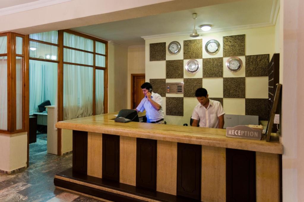 two men standing at a counter in a lobby at Marvıda Hotel Akman Park in Kemer