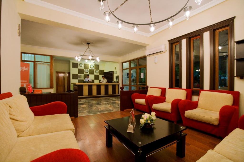 a living room with red chairs and a table at Marvıda Hotel Akman Park in Kemer