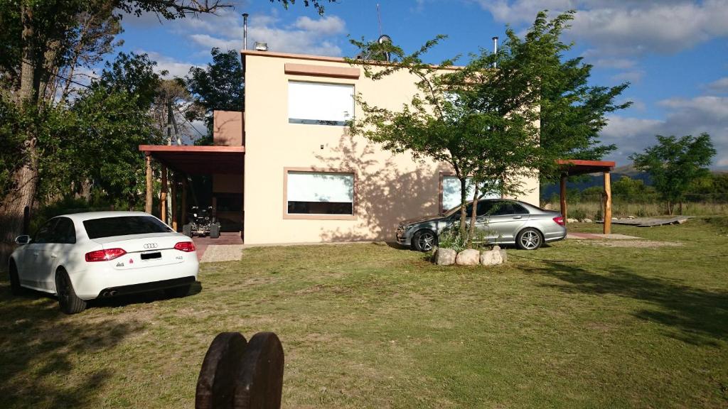 two cars parked in front of a house at Terrazas de Villa Gloria in Villa Giardino