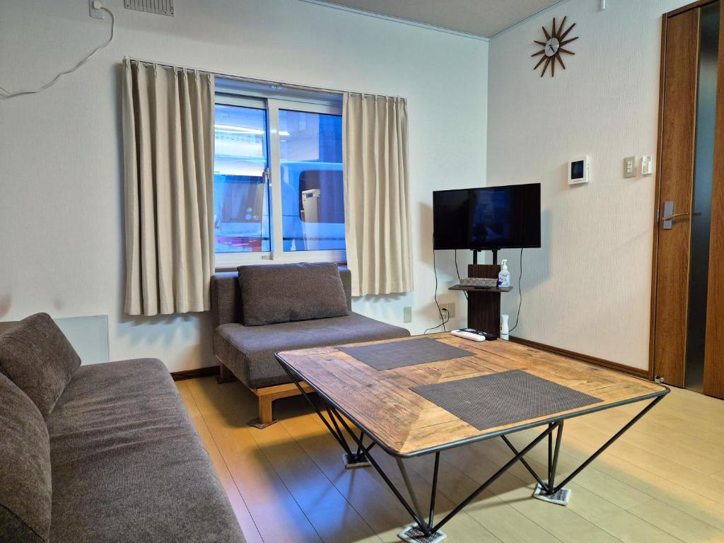 a living room with a couch and a table at KitaのHikari in Sapporo