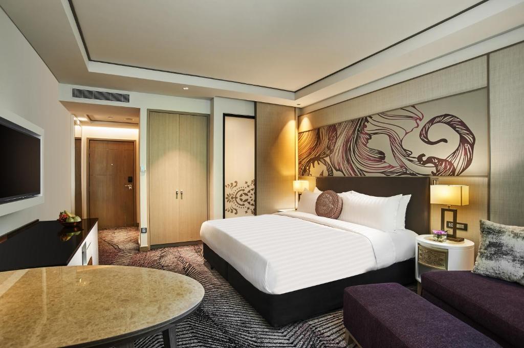 a hotel room with a large bed and a large mirror at Amari Johor Bahru in Johor Bahru