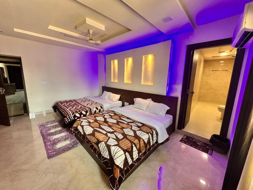 two beds in a room with purple lights at Taj Castle Homestay in Agra