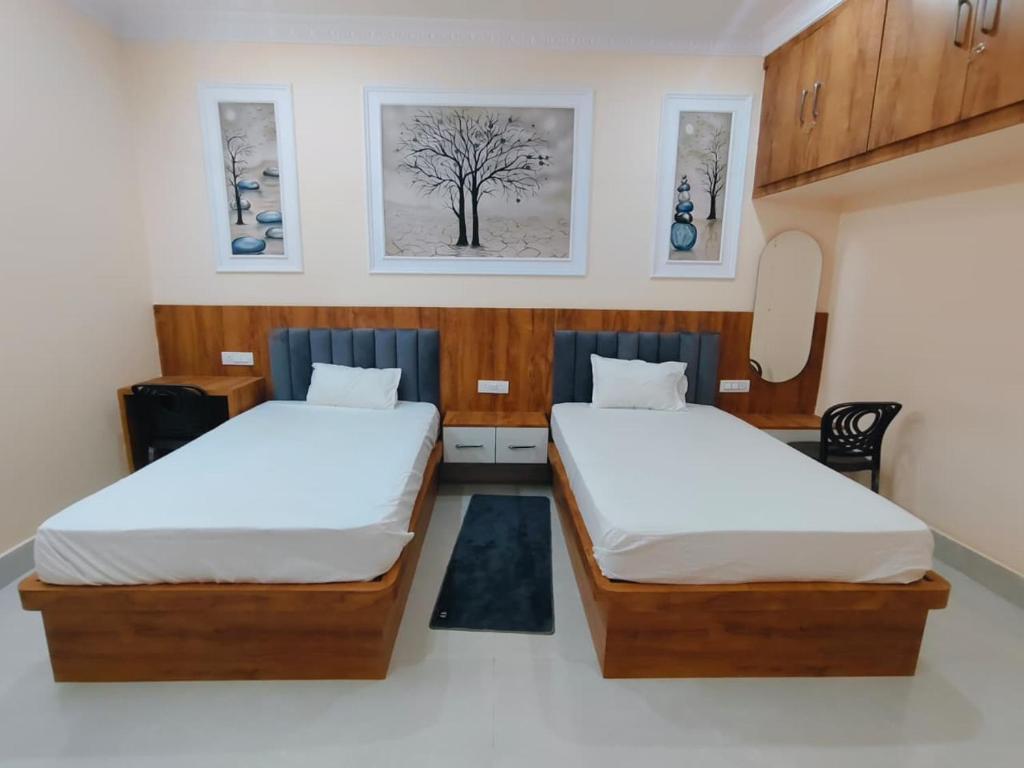 a room with two beds and two pictures on the wall at Hotel Orchha Heritage in Orchha