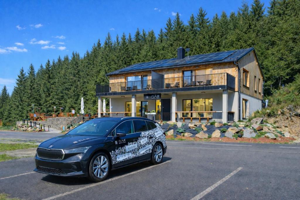 a car parked in a parking lot in front of a house at Fláje Apartmány in Český Jiřetín